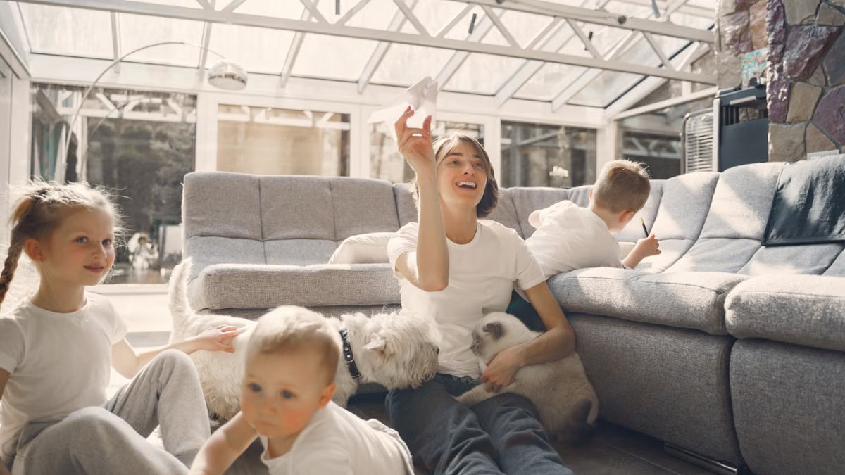 A joyful family with children and pets having fun indoors, enjoying leisure time together.